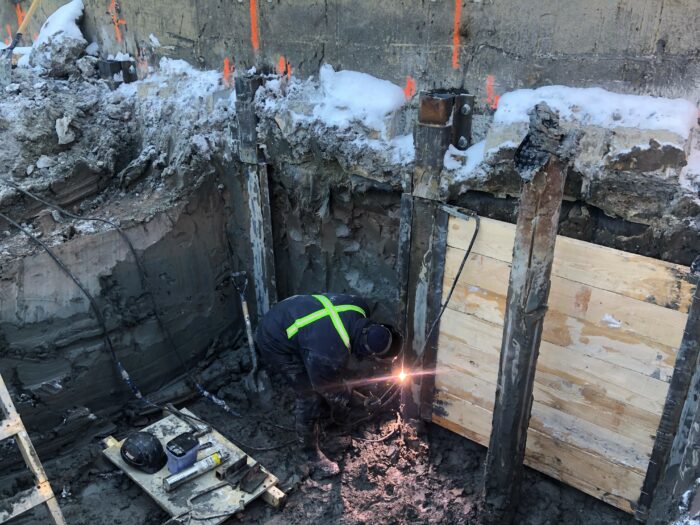 Interpile sheeting step to create a retaining wall